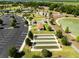 Aerial view of a park with lake, parking lot, and recreational facilities at 5325 Zisa Ct, The Villages, FL 32163