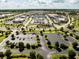 Aerial view of shops and parking lots in a sunny community with well-manicured medians and sidewalks at 5325 Zisa Ct, The Villages, FL 32163
