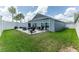Spacious backyard with a patio featuring a fire pit and lush green lawn for outdoor enjoyment at 5325 Zisa Ct, The Villages, FL 32163