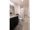 Well-lit bathroom with modern black vanity and shower/tub combo with updated subway tile at 5325 Zisa Ct, The Villages, FL 32163