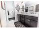 Modern bathroom features a dual sink vanity, marble countertop and a tiled walk-in shower with glass door at 5325 Zisa Ct, The Villages, FL 32163