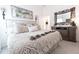 Cozy bedroom featuring a decorative bed, floral artwork and a rustic TV stand with mirror at 5325 Zisa Ct, The Villages, FL 32163