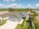 Home featuring a spacious driveway, a two-car garage, and manicured landscaping under a sunny sky at 5325 Zisa Ct, The Villages, FL 32163