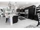 Modern kitchen with black cabinets, stainless steel appliances, and stylish lighting fixtures at 5325 Zisa Ct, The Villages, FL 32163