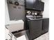 Modern laundry room with gray walls, dark cabinets, utility sink and front load washer/dryer set at 5325 Zisa Ct, The Villages, FL 32163
