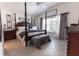 Spacious primary bedroom featuring a four poster bed, decorative accents and tile floors at 5325 Zisa Ct, The Villages, FL 32163