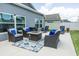Relaxing patio area with comfortable seating, fire pit, and well-manicured lawn under blue sky at 5325 Zisa Ct, The Villages, FL 32163