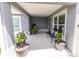 Inviting covered patio with seating, potted plants, and a serene view creating a peaceful outdoor retreat at 5325 Zisa Ct, The Villages, FL 32163