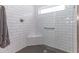 Walk-in shower featuring white subway tile, black hexagon tile flooring, and a corner seat at 5325 Zisa Ct, The Villages, FL 32163