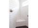 Corner shower showcasing white subway tile, black hexagon tile floor and a built-in corner seat at 5325 Zisa Ct, The Villages, FL 32163
