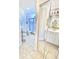 Bright bathroom with shower and toilet behind glass doors and mirrors at 5373 Compass Pt # 1, Oxford, FL 34484