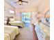 Sunlit bedroom features two beds, a ceiling fan, and a sliding glass door to the outside at 5373 Compass Pt # 1, Oxford, FL 34484