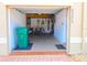 View of a well-lit garage storing bicycles, cleaning supplies, and a trash receptacle at 5373 Compass Pt # 1, Oxford, FL 34484