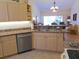 Spacious open kitchen with stainless steel dishwasher overlooking the living room at 5373 Compass Pt # 1, Oxford, FL 34484