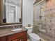 This bathroom offers a tiled walk-in shower, granite counters, and a framed mirror at 5530 Oxford Moor Blvd, Windermere, FL 34786