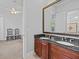 Modern bathroom featuring a dark granite double vanity, ceiling fan, and antique chairs at 5530 Oxford Moor Blvd, Windermere, FL 34786