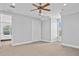 Bright bedroom with neutral carpet, ceiling fan, closet, and window at 5530 Oxford Moor Blvd, Windermere, FL 34786
