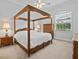 Beautiful bedroom featuring a wooden four poster bed, soft carpet, window, and matching nightstands at 5530 Oxford Moor Blvd, Windermere, FL 34786