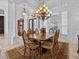 A traditionally styled dining room is illuminated by an ornate chandelier, features an antique clock and ample windows at 5530 Oxford Moor Blvd, Windermere, FL 34786