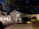 Beautiful home at night featuring exterior lighting, a well-manicured lawn, and a charming front fountain at 5530 Oxford Moor Blvd, Windermere, FL 34786