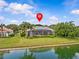 Back exterior view of the property with a screened-in pool, landscaped yard, and serene lakeside setting at 5530 Oxford Moor Blvd, Windermere, FL 34786