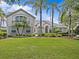 Beautiful home featuring lush green grass, swaying palm trees, manicured shrubs and tasteful landscaping around the property at 5530 Oxford Moor Blvd, Windermere, FL 34786