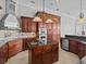 Chef's kitchen with dark wood cabinetry, stainless steel appliances, granite countertops, and a functional center island at 5530 Oxford Moor Blvd, Windermere, FL 34786