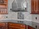 A close-up of a kitchen corner, featuring a sleek vent hood and decorative tile backsplash at 5530 Oxford Moor Blvd, Windermere, FL 34786