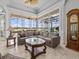A living room with large windows offering views of the lake, a sectional couch and glass coffee table at 5530 Oxford Moor Blvd, Windermere, FL 34786