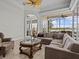 A living room with large windows offering views of the lake, a sectional couch and glass coffee table at 5530 Oxford Moor Blvd, Windermere, FL 34786