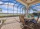 Relaxing outdoor patio area with a dining table, chairs, and tranquil views of the pool and surrounding community lake at 5530 Oxford Moor Blvd, Windermere, FL 34786