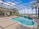 A sparkling screened-in pool area offers serene views of the adjacent lake, blending relaxation with picturesque scenery at 5530 Oxford Moor Blvd, Windermere, FL 34786