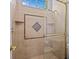 Updated tiled shower featuring a glass door, accent tile, shower head, and built-in shelving at 5530 Oxford Moor Blvd, Windermere, FL 34786