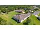 Aerial view of a serene home showcasing screened-in patio, lush landscaping, and a generous yard in a quiet neighborhood at 5941 Sage Leaf Pl, Leesburg, FL 34748
