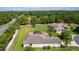 Aerial view showcases the home's lush surroundings, including a screened-in patio and a large yard, near a main road at 5941 Sage Leaf Pl, Leesburg, FL 34748