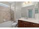 Well-lit bathroom features a bathtub with shower, toilet and vanity with dark wood cabinets at 5941 Sage Leaf Pl, Leesburg, FL 34748