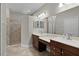 Bathroom featuring double sinks and walk-in shower with neutral paint and light fixtures at 5941 Sage Leaf Pl, Leesburg, FL 34748