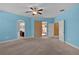Bedroom with neutral carpet, three access doors and lots of sunlight at 5941 Sage Leaf Pl, Leesburg, FL 34748