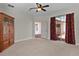 Bedroom with ceiling fan, carpet, and sliding door access to lanai at 5941 Sage Leaf Pl, Leesburg, FL 34748