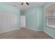 A light blue bedroom with carpet, ceiling fan, closet, and natural light at 5941 Sage Leaf Pl, Leesburg, FL 34748