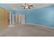 Large bedroom with three doorways, neutral carpet, and blue paint at 5941 Sage Leaf Pl, Leesburg, FL 34748