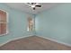 A serene bedroom with light blue walls, carpeted floors, and bright windows at 5941 Sage Leaf Pl, Leesburg, FL 34748