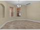 Cozy dining room featuring tile floors, neutral walls, chandelier, and natural light from two windows at 5941 Sage Leaf Pl, Leesburg, FL 34748
