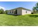 Spacious single-story home featuring a well-maintained lawn, neutral paint and sliding glass doors to the backyard at 5941 Sage Leaf Pl, Leesburg, FL 34748