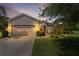 Charming single-story home with a two car garage, inviting curb appeal and a warm sunset glow at 5941 Sage Leaf Pl, Leesburg, FL 34748