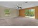 Spacious living room with neutral carpet and large windows offering natural light and views at 5941 Sage Leaf Pl, Leesburg, FL 34748