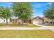 Charming single-Gathering home featuring a well-maintained lawn, a two-car garage, and complemented by mature trees at 597 Skyridge Rd, Clermont, FL 34711