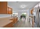 Modern kitchen offers wood cabinets, stainless steel refrigerator, and an open floor plan at 597 Skyridge Rd, Clermont, FL 34711