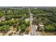 The aerial view showcases a road running through a lush, green landscape of trees and scattered houses at 600 Powell St, Wildwood, FL 34785