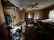 Interior shot of a cluttered bedroom with damage to ceiling and walls and personal items strewn about at 600 Powell St, Wildwood, FL 34785
